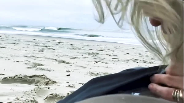 Vacationers look on with disapproval as a milf with her BF films anal content right on the beach