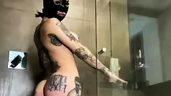 Peituda de capuz de látex se masturba no chuveiro