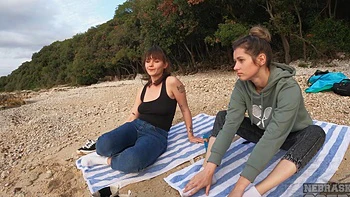 Two young girls play on the beach and get naughty with socks